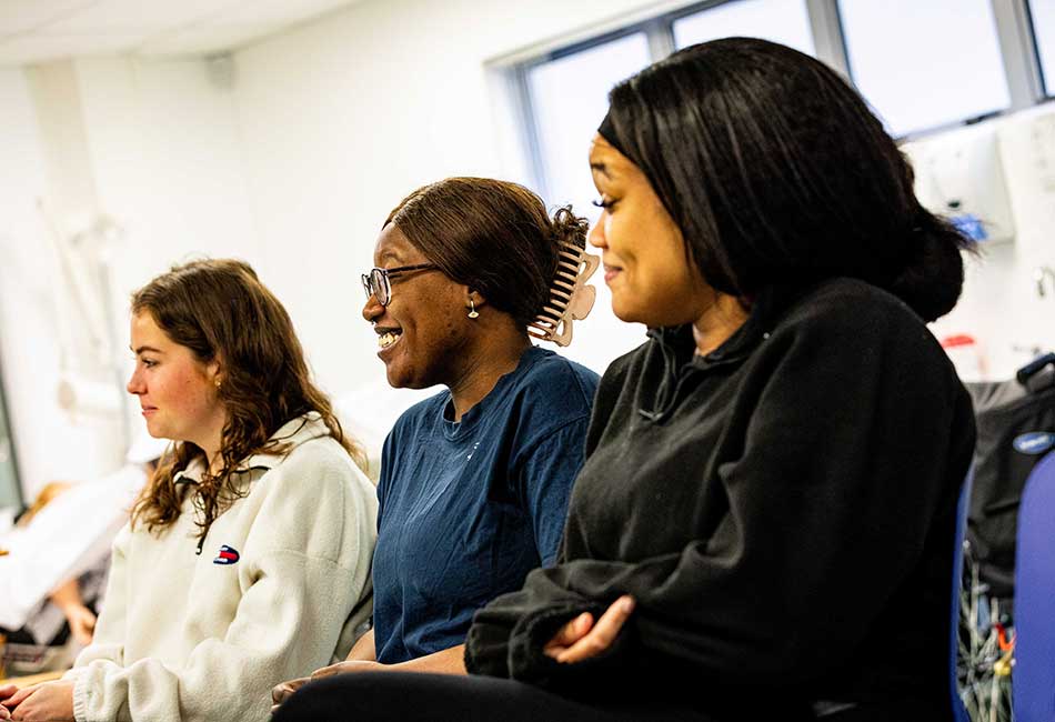 A couple of smiling students sat in a row.