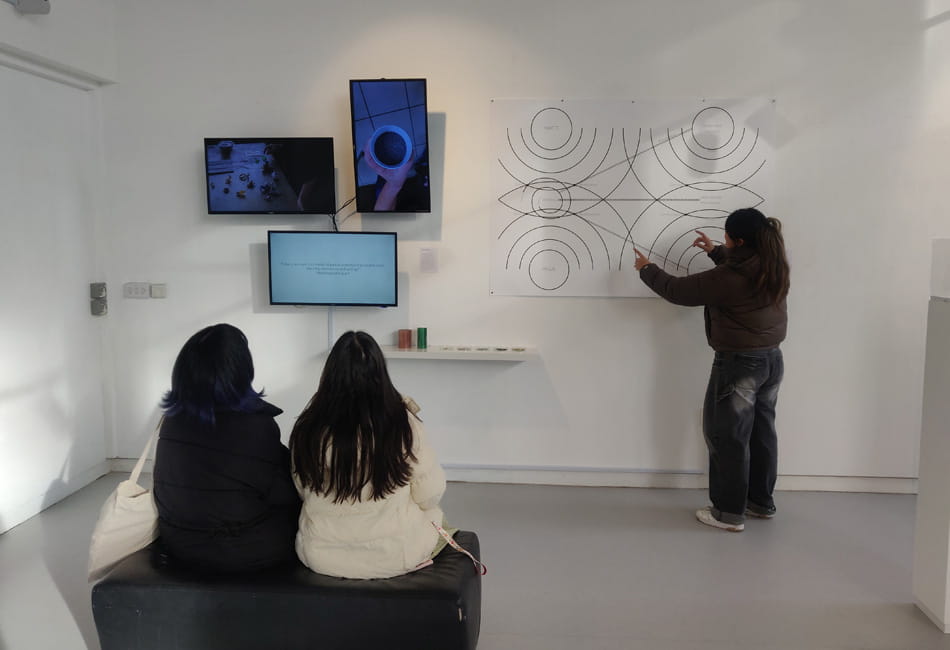 People sitting in a gallery observing an interactive piece of art.