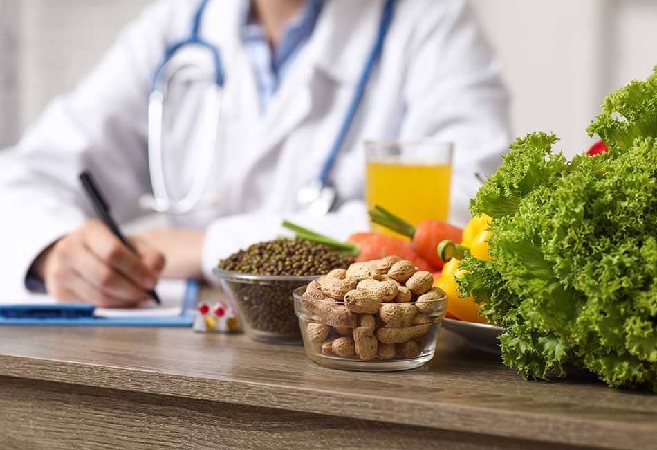 Female nutritionist writing on a clipboard with healthy foods in a bowl in front of her.