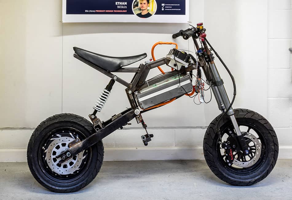 A small motorcycle under a display board in a room.