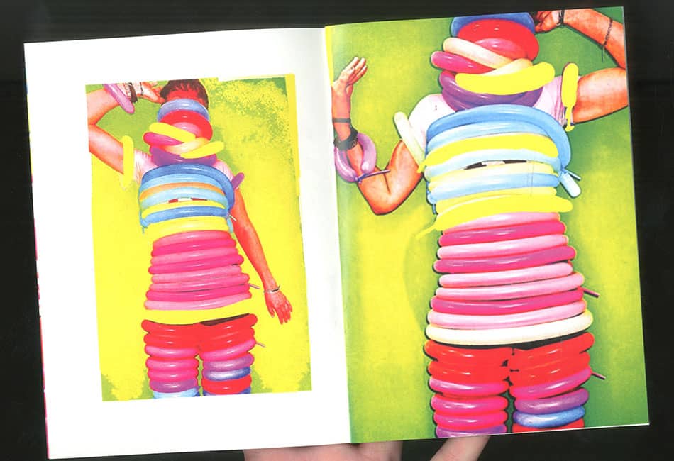 A student wearing elf ears modelling shorts and t-shirt stood between two classical paintings.