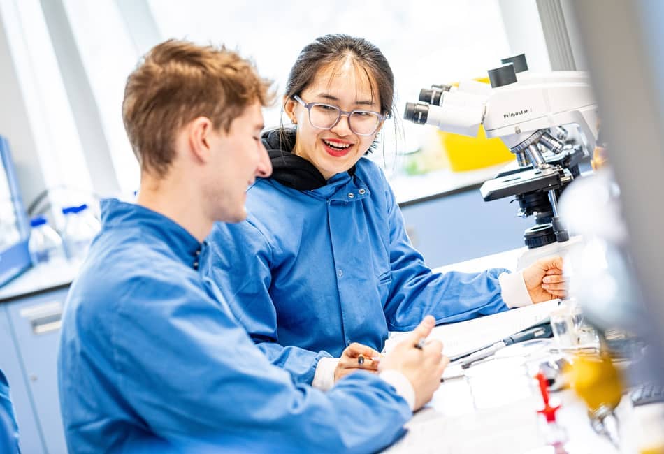 Two students working together in a science lab.