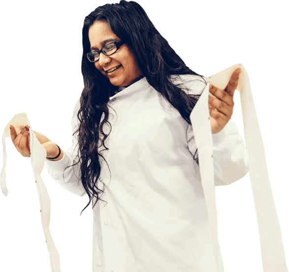 A Health Professions degree student wearing white and holding some paper